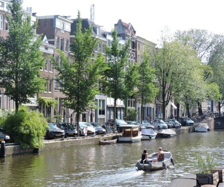 Deux personnes naviguant en bateau sur un canal d'Amsterdam.